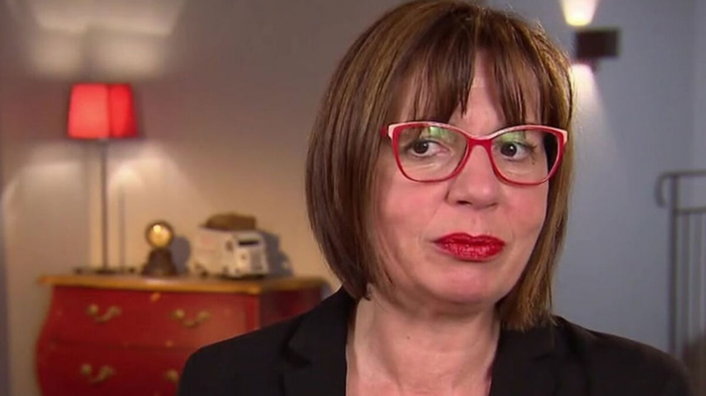 Portrait d’une intervenante d’émission éducative regardant la caméra dans un intérieur calme après une séquence médiatique très commentée