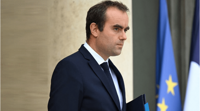 Responsable politique en costume sombre marchant à l’extérieur d’un bâtiment officiel avec des drapeaux en arrière-plan