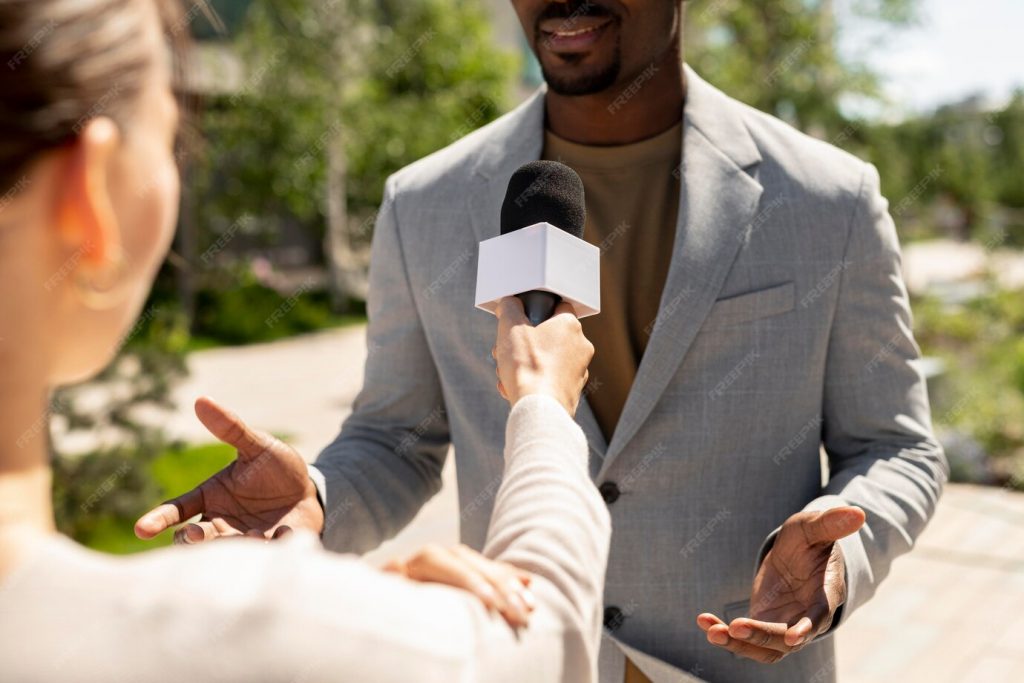 Interview d’un homme adulte en extérieur répondant à une question face à un micro tenu par une journaliste, scène illustrant un témoignage sur un changement de mode de vie lié à la santé.