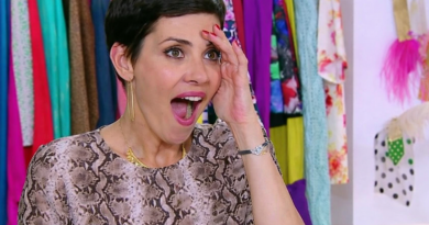 Animatrice de télévision réagissant avec surprise devant une garde-robe colorée, la main sur le front et la bouche ouverte, exprimant un enthousiasme spontané.