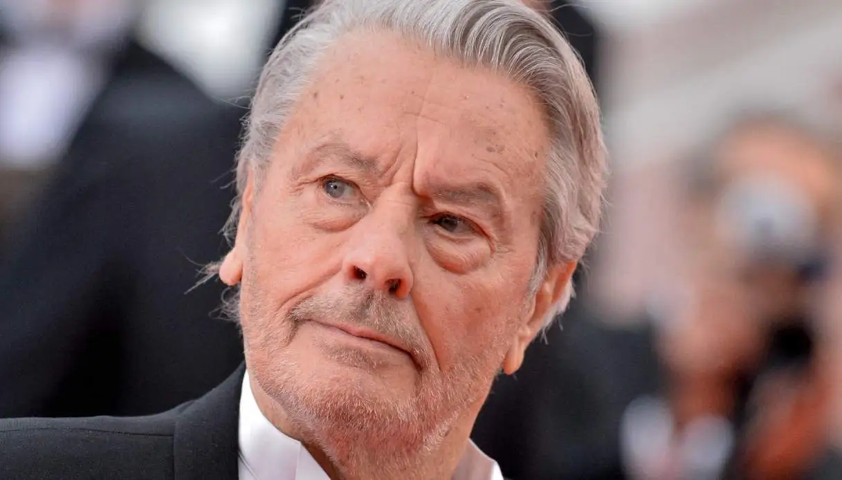 Portrait d’un acteur français âgé au regard sérieux lors d’un événement public, image illustrant les tensions familiales autour d’un héritage médiatisé