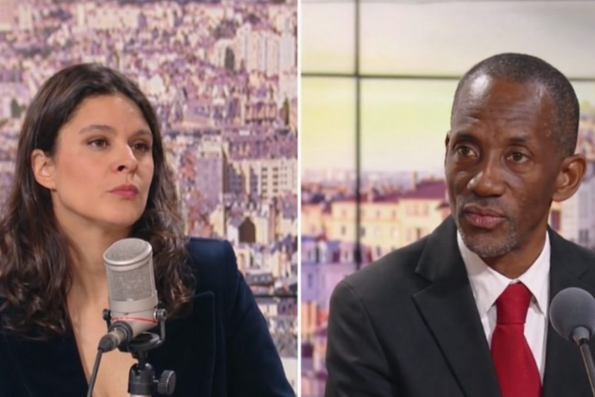 journaliste en plateau télévision face à un élu politique lors d’une interview tendue en direct avec microphones visibles