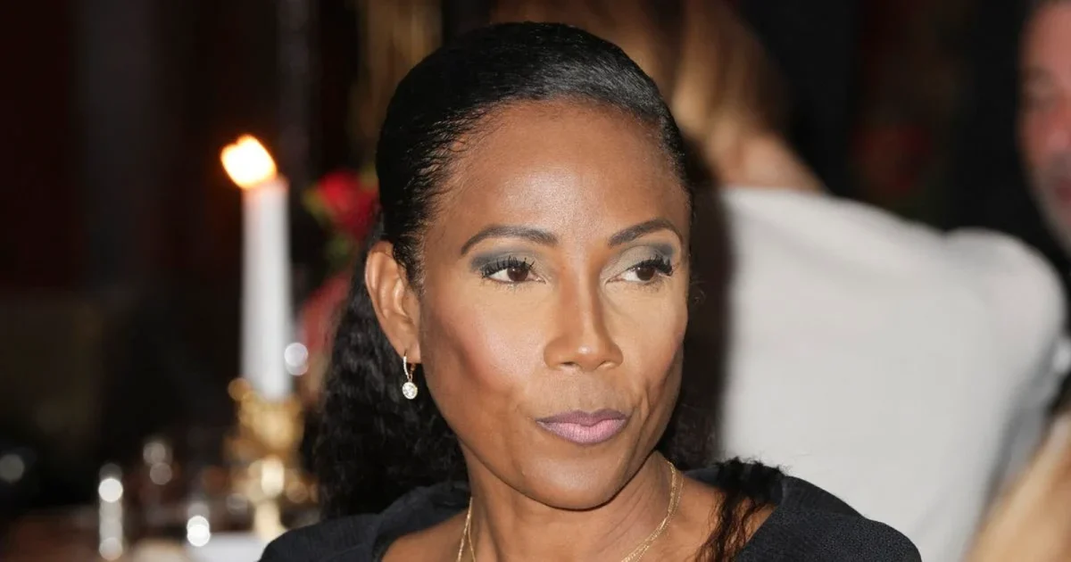 portrait femme élégante regard sérieux maquillage soigné cheveux attachés lumière chaude ambiance soirée bougie floue arrière-plan tenue sombre expression concentrée présence médiatique absence télévision intrigue téléspectateurs
