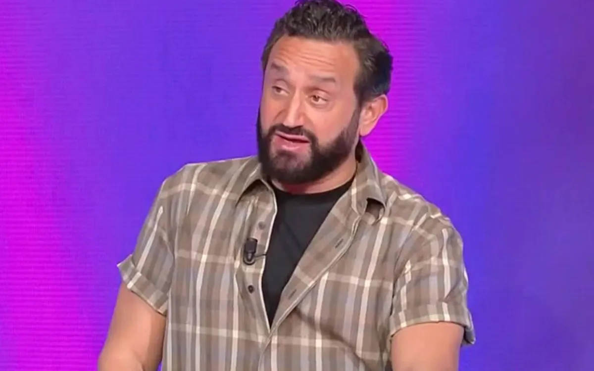 Animateur télé en plateau regard sérieux s’exprimant avec intensité face caméra sur fond violet, ambiance tendue et débat médiatique