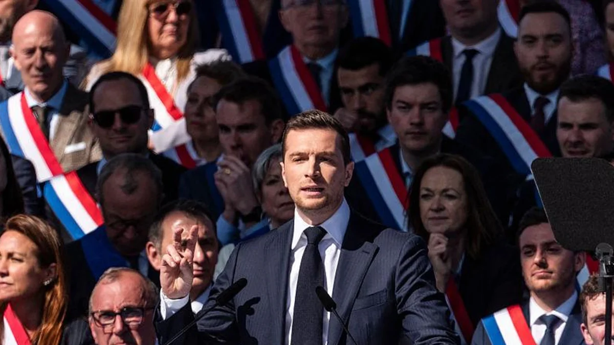Responsable politique français prononçant un discours lors d’un rassemblement politique devant une foule d’élus et de militants portant des écharpes tricolores.