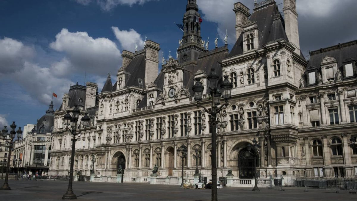 Façade d’un grand bâtiment administratif historique au cœur d’une capitale européenne, architecture monumentale avec tours, statues et lampadaires, ciel nuageux au-dessus d’une place vide dans un contexte d’actualité judiciaire