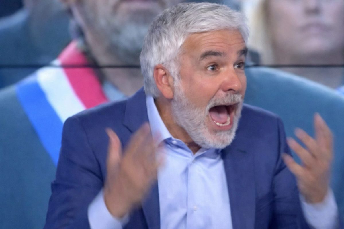 animateur radio en plein direct avec expression choquée et gestes vifs, dans un studio télévisé, illustrant un moment de tension et d’imprévu à l’antenne