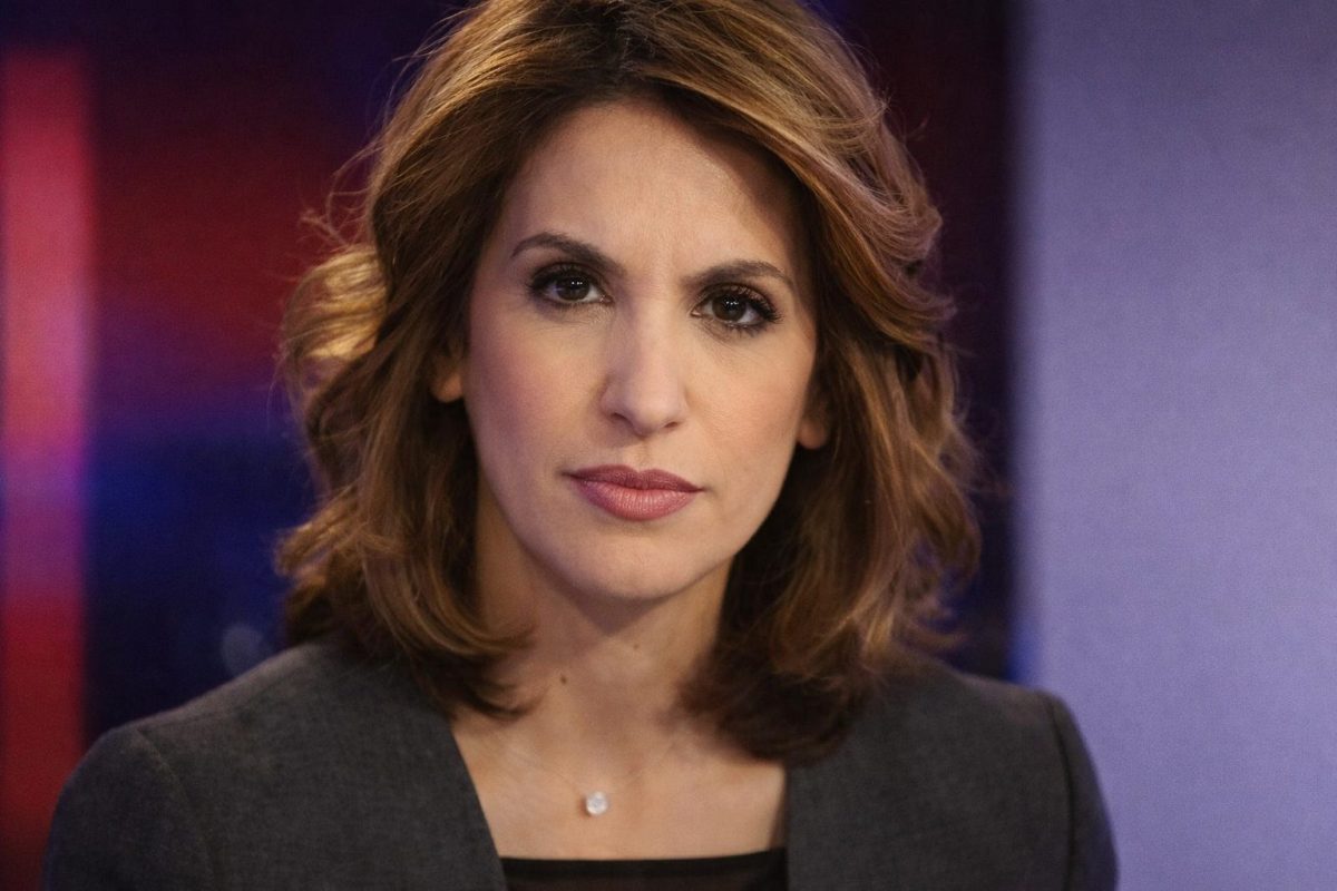 Journaliste en gros plan en studio télé, regard intense face caméra, visage centré occupant la majorité de l’image, éclairage contrasté avec fond flou coloré, ambiance tendue et dramatique évoquant des tensions médiatiques.