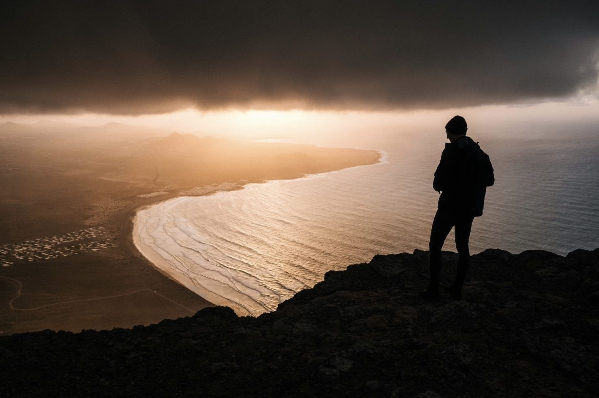 Personne assise seule face à l’horizon au lever du soleil, symbole de reconstruction personnelle et de nouveau départ après des années de souffrance et d’addictions.