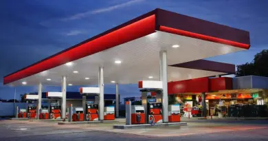 station-service moderne sans logo ni marque avec pompes à essence sous un auvent éclairé au crépuscule illustrant le carburant et le prix de l’essence en France en 2026