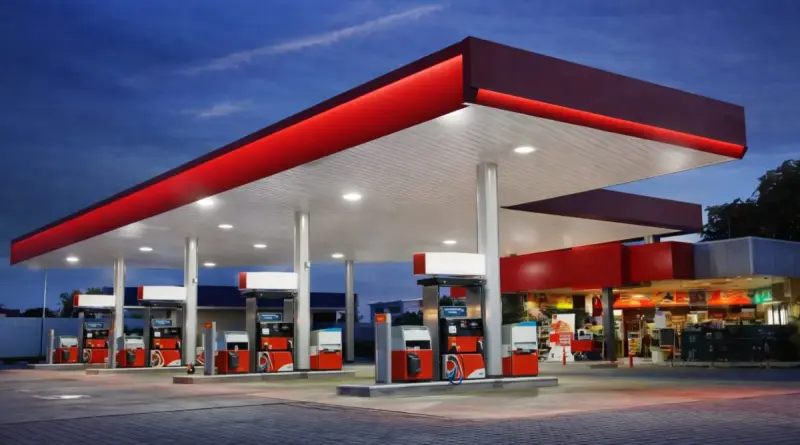 station-service moderne sans logo ni marque avec pompes à essence sous un auvent éclairé au crépuscule illustrant le carburant et le prix de l’essence en France en 2026