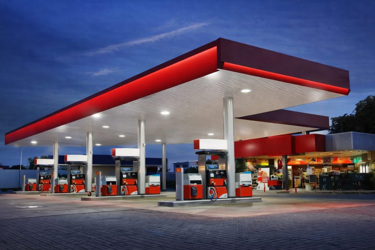 station-service moderne sans logo ni marque avec pompes à essence sous un auvent éclairé au crépuscule illustrant le carburant et le prix de l’essence en France en 2026