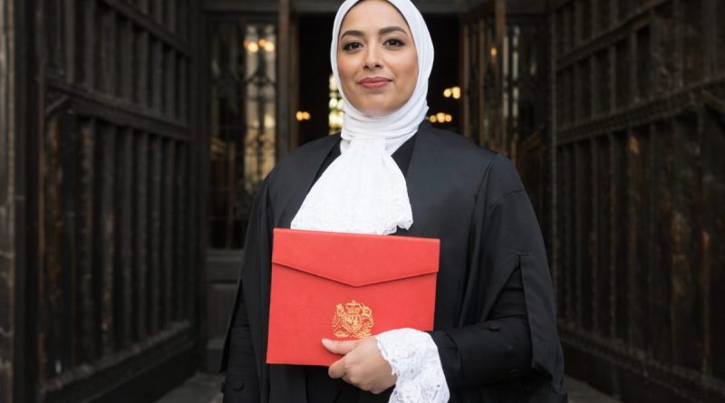 Avocate portant une robe noire et un voile blanc devant l’entrée d’un tribunal, tenant un dossier rouge, illustrant le débat sur le port de signes religieux et la neutralité dans la justice en France.