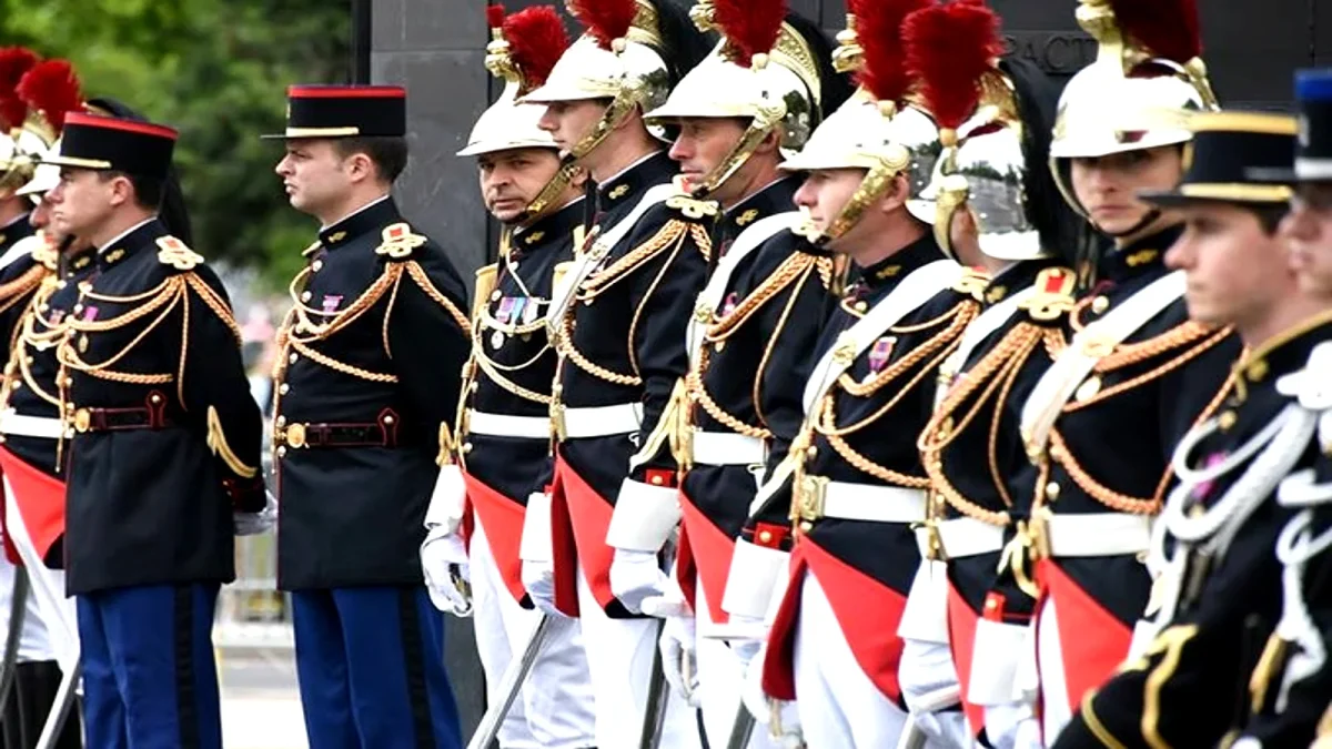 Alignement de cavaliers en uniforme de cérémonie avec casques ornés de plumes rouges lors d’un rassemblement officiel, illustrant une institution militaire française dans un contexte de discipline et de tension liée à une affaire de discrimination