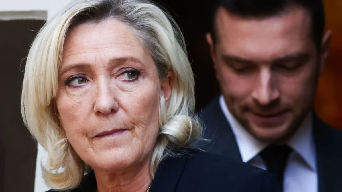Femme politique au regard préoccupé au premier plan, avec un homme en arrière-plan flou, illustrant les tensions liées au financement d’une campagne présidentielle et aux difficultés d’accès au crédit