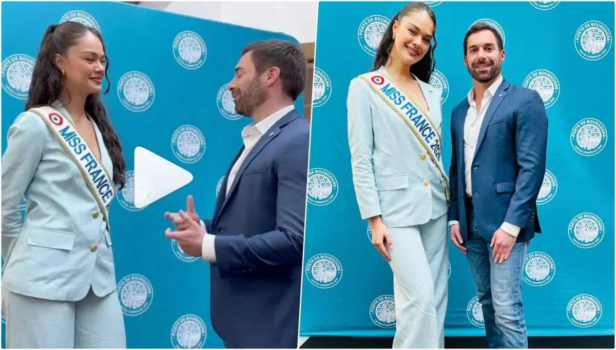 Jeune femme élue Miss France portant une écharpe officielle posant aux côtés d’un homme en costume lors d’une rencontre publique dans un centre commercial, devant un mur bleu avec logos, ambiance médiatique et séance photo