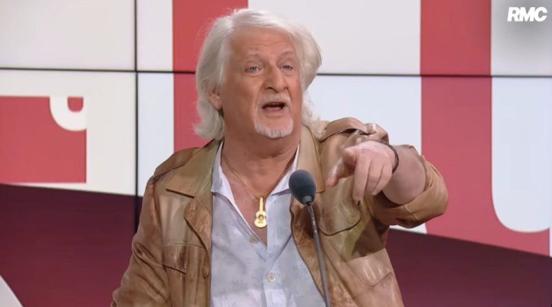 Animateur et humoriste en studio radio en train de pointer du doigt avec intensité lors d’un débat en direct, expression déterminée et ton polémique