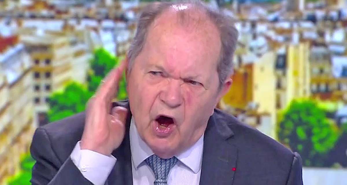 homme âgé en costume s’exprimant avec colère sur un plateau télévisé, geste marqué et visage tendu, dans un contexte de débat médiatique polémique