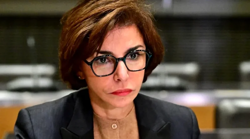 Portrait serré d’une femme politique au regard grave et concentré, assise dans un environnement institutionnel flou, ambiance tendue évoquant une défaite électorale et une polémique médiatique en France