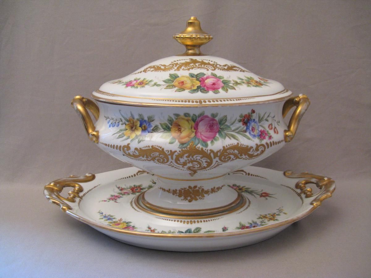 Soupière ancienne en Porcelaine de Limoges décorée de motifs floraux colorés et de détails dorés raffinés, présentée avec son plat assorti dans un style élégant inspiré des arts de la table français.