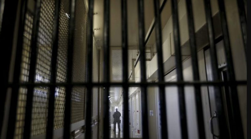 Vue d'un couloir de prison française photographié derrière des barreaux métalliques, illustrant les conditions de détention et le débat sur la climatisation des établissements pénitentiaires pendant les épisodes de canicule en France.