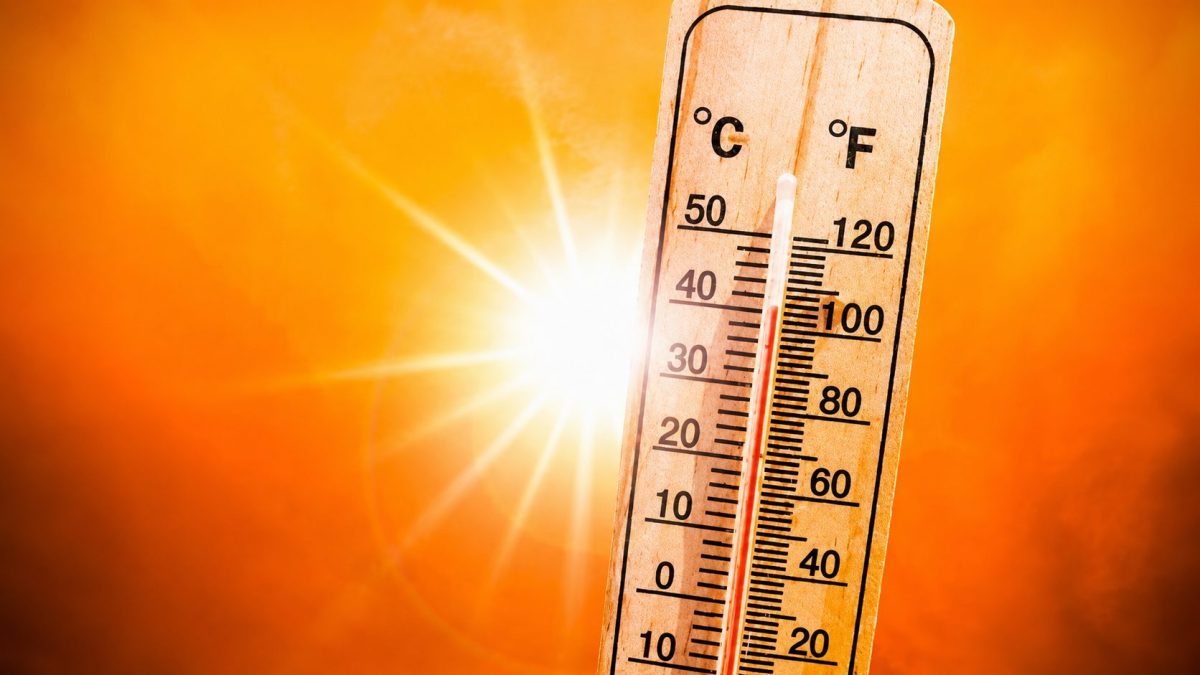 Thermomètre affichant une température très élevée sous un soleil éclatant dans un ciel orange, illustrant la canicule, les fortes chaleurs et les températures extrêmes en France.