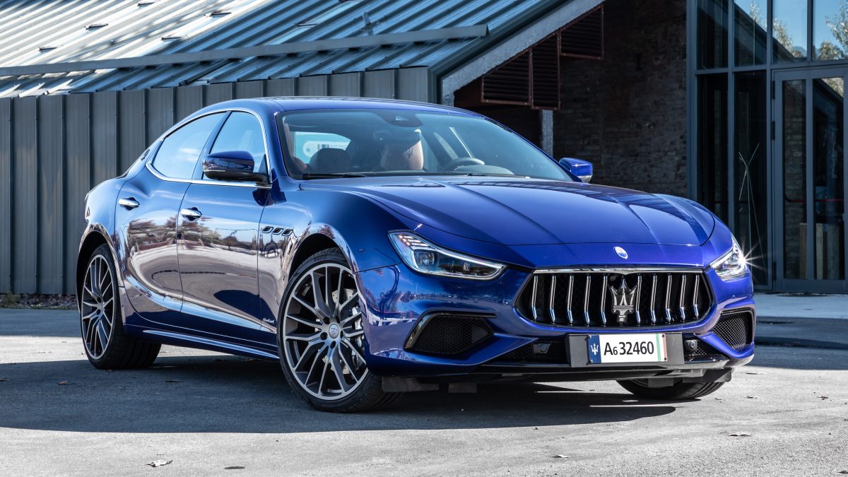 Une Maserati Ghibli bleue stationnée devant un bâtiment moderne. Le véhicule illustre l'affaire d'un ancien chef cuisinier du Tarn poursuivi pour fraude aux allocations chômage, fraude fiscale et blanchiment présumé d'argent après avoir perçu plus de 41 000 euros d'indemnités chômage tout en continuant à exercer son activité dans son restaurant.