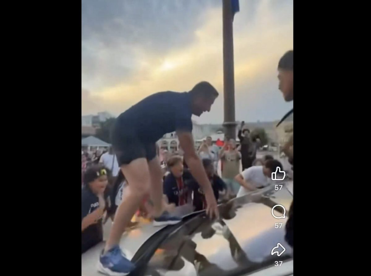 Un homme monte sur le capot d’une voiture au milieu d’une foule de supporters célébrant une victoire historique de football dans une ville française. La scène, filmée en soirée, montre une ambiance festive et agitée qui a déclenché une importante polémique sur les réseaux sociaux.