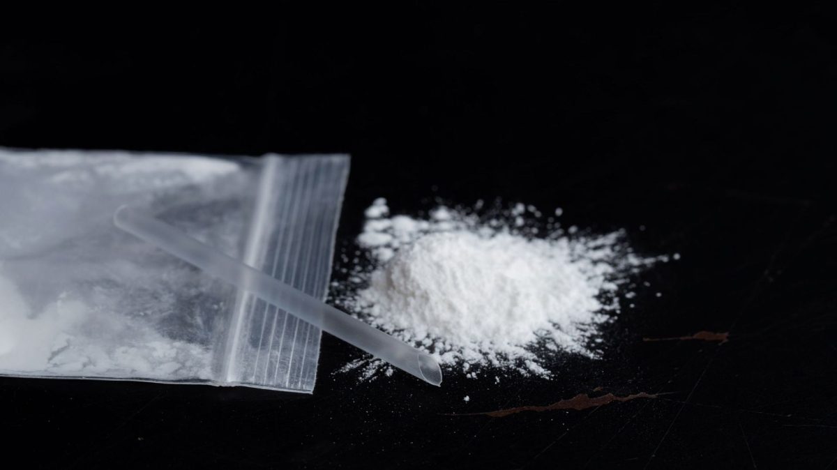 Gros plan sur un sachet plastique transparent, une poudre blanche et une paille posés sur une surface noire, illustrant le combat contre l'addiction, la tentation de replonger et le choix de préserver son abstinence dans le cadre d'un témoignage personnel.