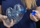 Personne tenant une bouteille en plastique PET écrasée avec son bouchon à la main, illustrant les consignes de tri sélectif et les bonnes pratiques pour le recyclage des bouteilles en plastique en France.