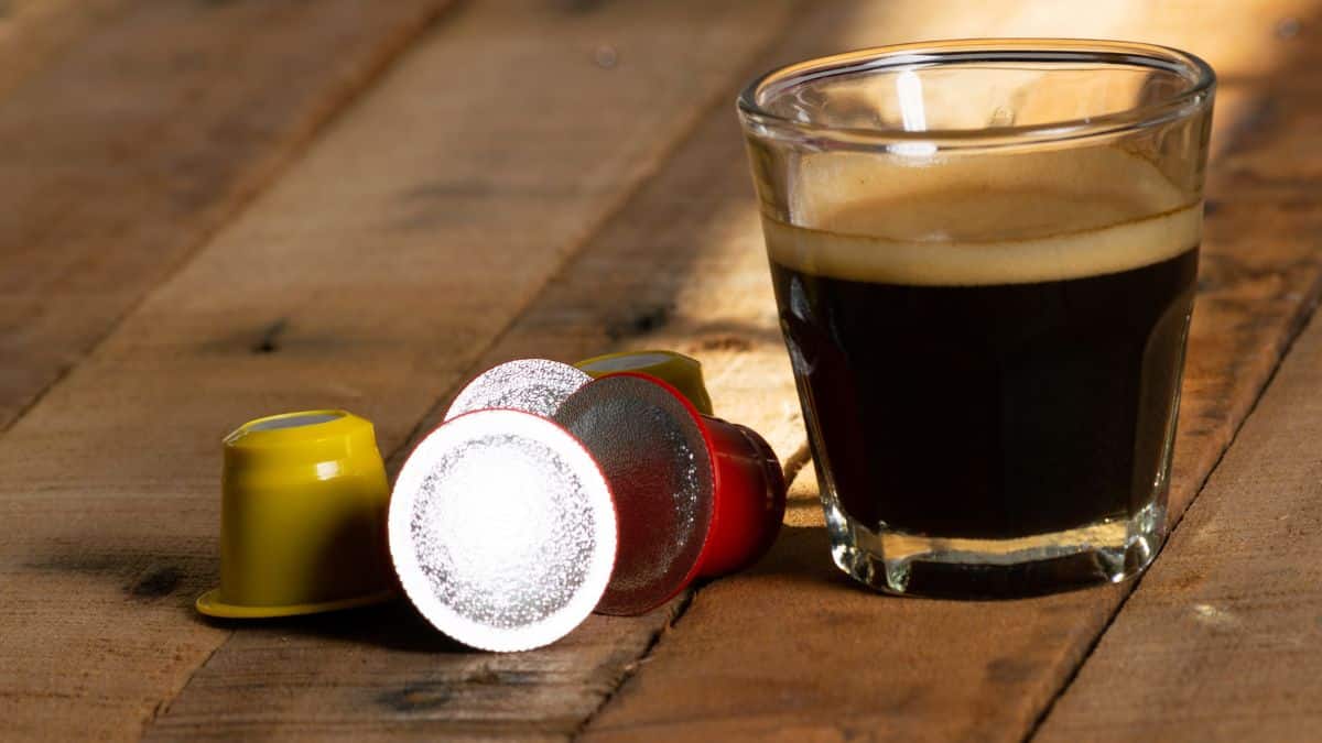 Capsules de café compatibles Nespresso posées à côté d'un expresso dans un verre, illustration d'un comparatif réalisé par 60 Millions de consommateurs sur les meilleures et les moins bonnes capsules de café vendues en supermarché selon leur composition, la présence de pesticides, d'hydrocarbures aromatiques polycycliques (HAP), d'acrylamide et d'autres contaminants.