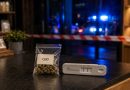 Sachet de fleurs de CBD et test salivaire sur le comptoir d’une boutique fermée, avec des gyrophares de gendarmerie en arrière-plan.