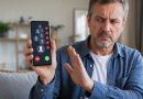 Homme agacé faisant un geste de refus devant un smartphone affichant plusieurs appels commerciaux, pour illustrer l’interdiction du démarchage téléphonique sans consentement dès le 11 août 2026.