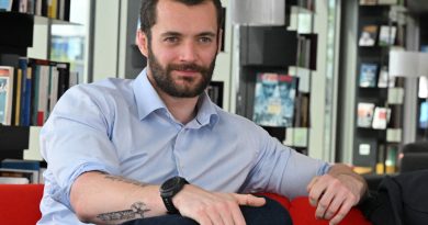 Louis Sarkozy lors d'une interview en France en 2026. Le fils de Nicolas Sarkozy est assis dans une bibliothèque, portant une chemise bleu clair, tandis que son actualité politique et l'affaire du pistolet à billes sur une policière refont surface.