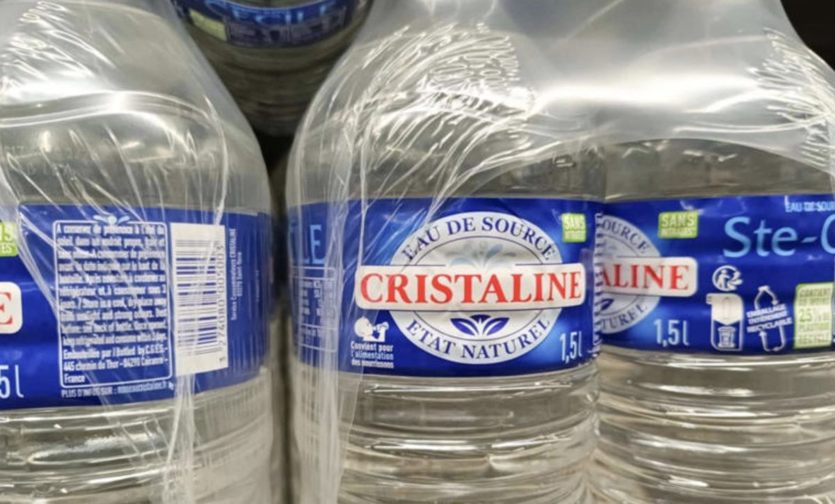 Packs de bouteilles d'eau Cristaline emballés dans un film plastique transparent, illustrant le débat autour du règlement européen PPWR et de la réduction des emballages plastiques à usage unique à partir de 2026.