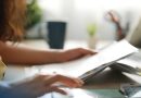 Une étudiante majeure consulte des documents administratifs liés à une demande de pension alimentaire pour financer ses études supérieures, après une décision de la Cour de cassation rappelant l'obligation des parents de contribuer à l'entretien et à l'éducation de leurs enfants majeurs.