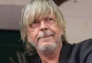 Portrait en gros plan du chanteur Renaud, débarqué avec son épouse Cerise d’un avion à destination du Canada après avoir vapoté à bord.
