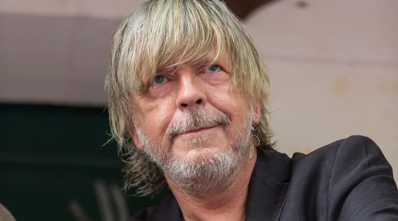 Portrait en gros plan du chanteur Renaud, débarqué avec son épouse Cerise d’un avion à destination du Canada après avoir vapoté à bord.