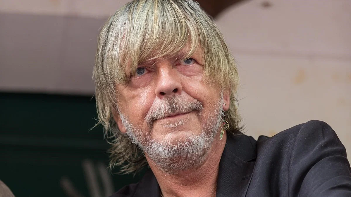 Portrait en gros plan du chanteur Renaud, débarqué avec son épouse Cerise d’un avion à destination du Canada après avoir vapoté à bord.