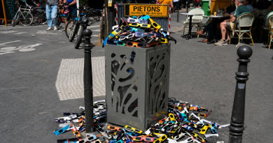 « Une poubelle publique déborde de lunettes de protection utilisées pour observer l’éclipse solaire, tandis que de nombreuses autres lunettes sont abandonnées sur le trottoir, illustrant la question des déchets, du gaspillage et de l’impact environnemental des objets utilisés pendant une très courte durée. »