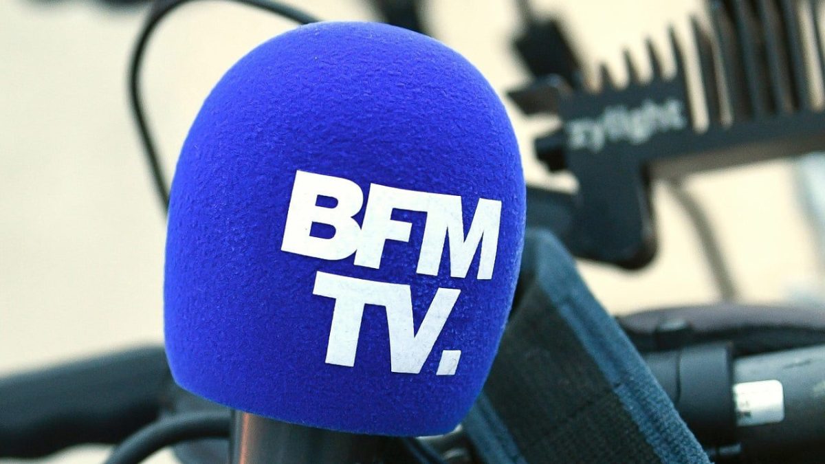 Micro bleu de BFMTV utilisé lors d'un reportage, illustrant la polémique autour d'une vidéo contenant des propos racistes diffusée sur les réseaux sociaux pendant les incendies en Gironde.