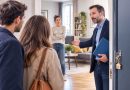 Illustration photoréaliste d'un propriétaire ou d'un agent immobilier faisant visiter un appartement loué à de potentiels acheteurs, tandis que le locataire, présent dans le logement, observe la scène. Cette image illustre les règles encadrant les visites d'un logement occupé pour une vente ou une relocation ainsi que les droits du locataire.