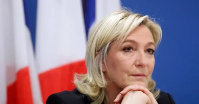 Portrait d’une femme politique française devant un drapeau tricolore, illustration du projet du RN visant à interdire le voile dans l’espace public et à sanctionner son port par une amende en cas de victoire à la présidentielle de 2027.