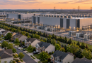 Vue aérienne d’un immense complexe de data centers à Ashburn, en Virginie, construit à proximité immédiate d’un quartier résidentiel américain, avec maisons, serveurs, installations électriques et lignes à haute tension.