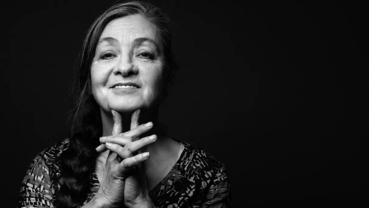 Portrait en noir et blanc de Catherine Ringer, chanteuse française et cofondatrice des Rita Mitsouko, posant devant un fond sombre.