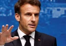 Homme en costume sombre prenant la parole devant un fond bleu, illustration d’un article sur le malaise signalé au GSPR et la protection du président de la République.