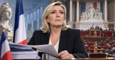 Marine Le Pen devant des documents budgétaires, avec l’Assemblée nationale et le drapeau français en arrière-plan, illustration de sa stratégie concernant le budget 2027 avant l’élection présidentielle.
