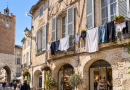 Linge étendu aux fenêtres et balcons d’immeubles anciens dans un centre-ville, illustration de l’interdiction décidée à Villeneuve-sur-Lot.