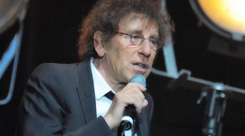 Alain Souchon, portant des lunettes et un costume sombre, s'exprime dans un micro sur scène. Le chanteur français a suscité une polémique en évoquant un départ en Suisse en cas de victoire du Rassemblement national, avant d'être défendu par Pierre Arditi. Copier l'ALT