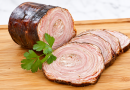 Andouille de Guémené traditionnelle coupée en tranches sur une planche en bois, illustrant le patrimoine culinaire breton aujourd'hui menacé.